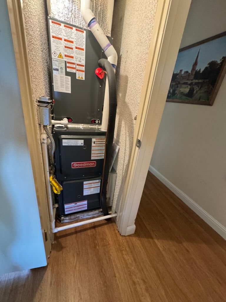 An air conditioner is installed in a closet in a hallway.