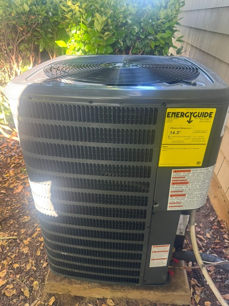 A large air conditioner is sitting on top of a wooden block.