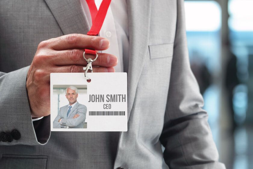 A man in a suit is holding a name tag that says john smith