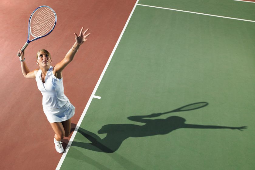 A woman is holding a tennis racquet on a tennis court