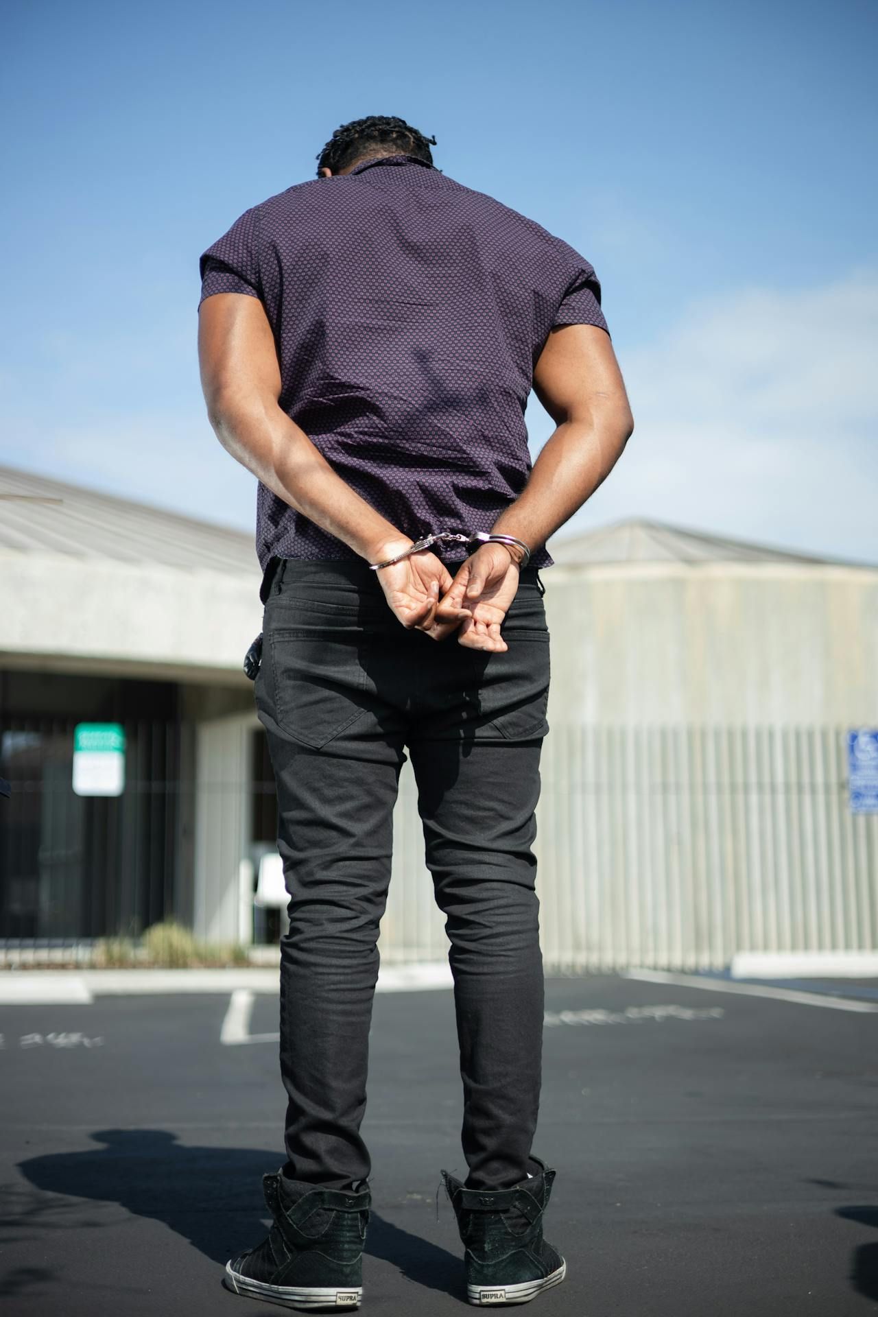 Rear View of Man Arrested In Handcuffs — Cairns Traffic Lawyers In Gordonvale, QLD