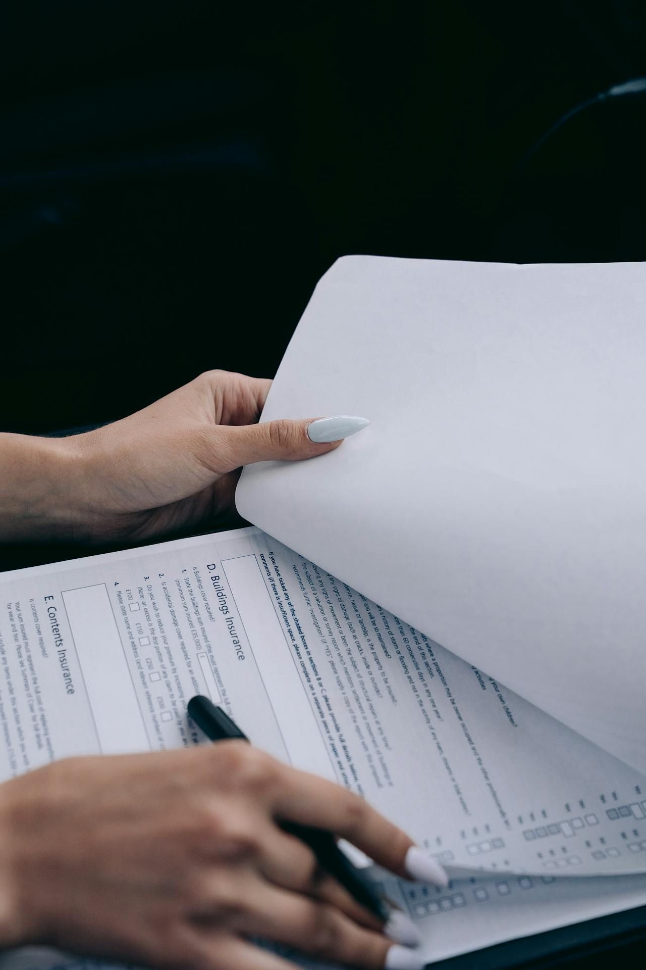 A Woman Is Filling Out A Form With A Pen — Cairns Traffic Lawyers In Cairns City, QLD