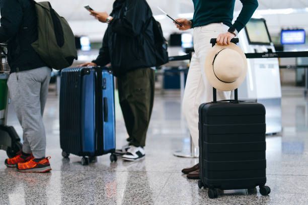 A group of people standing next to luggage at an airport.