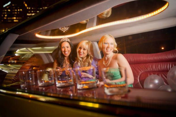 Three women are sitting in a limousine at a party.