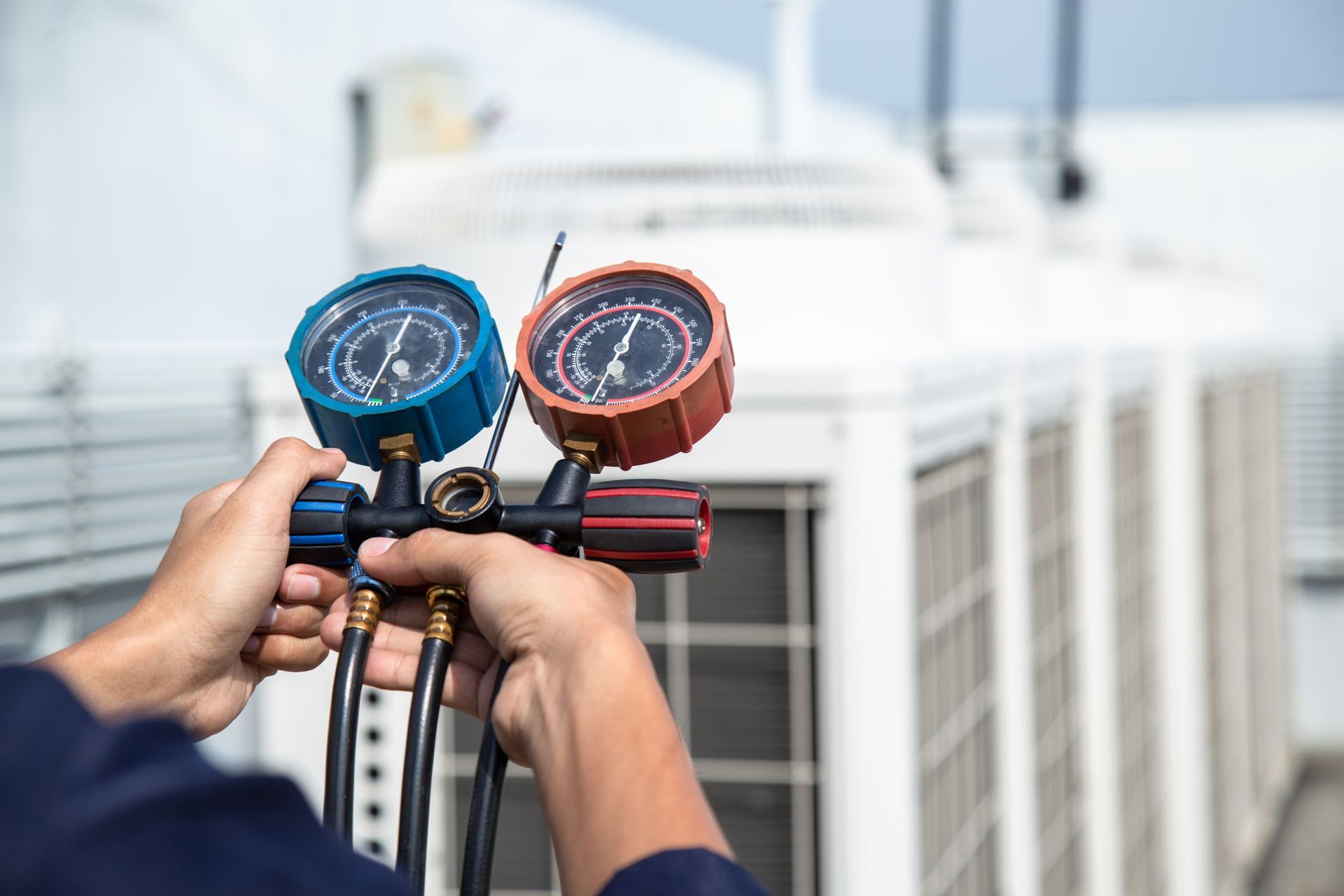 A man is holding two gauges in his hands in front of a building.