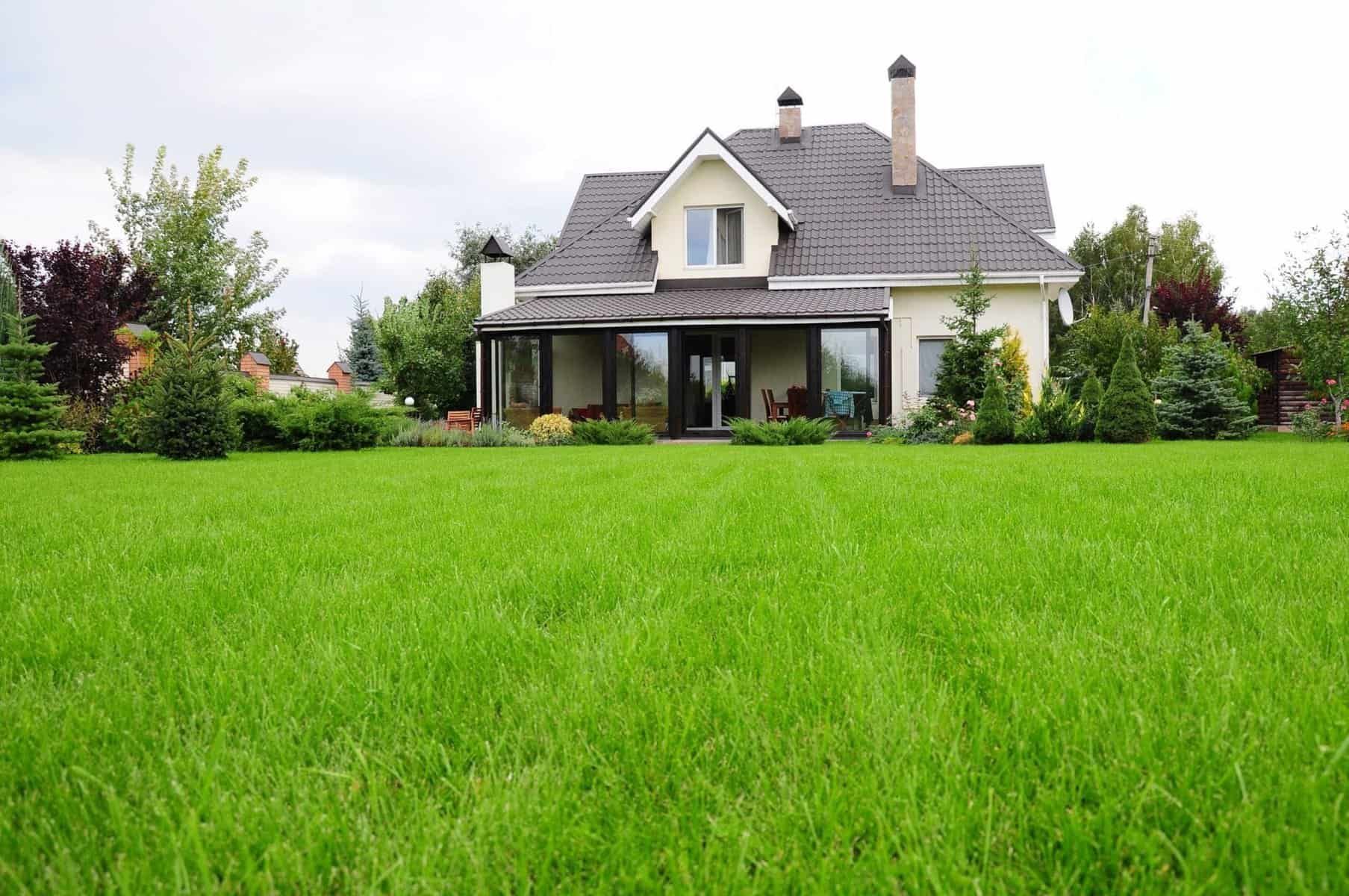 A large house with a lush green lawn in front of it.