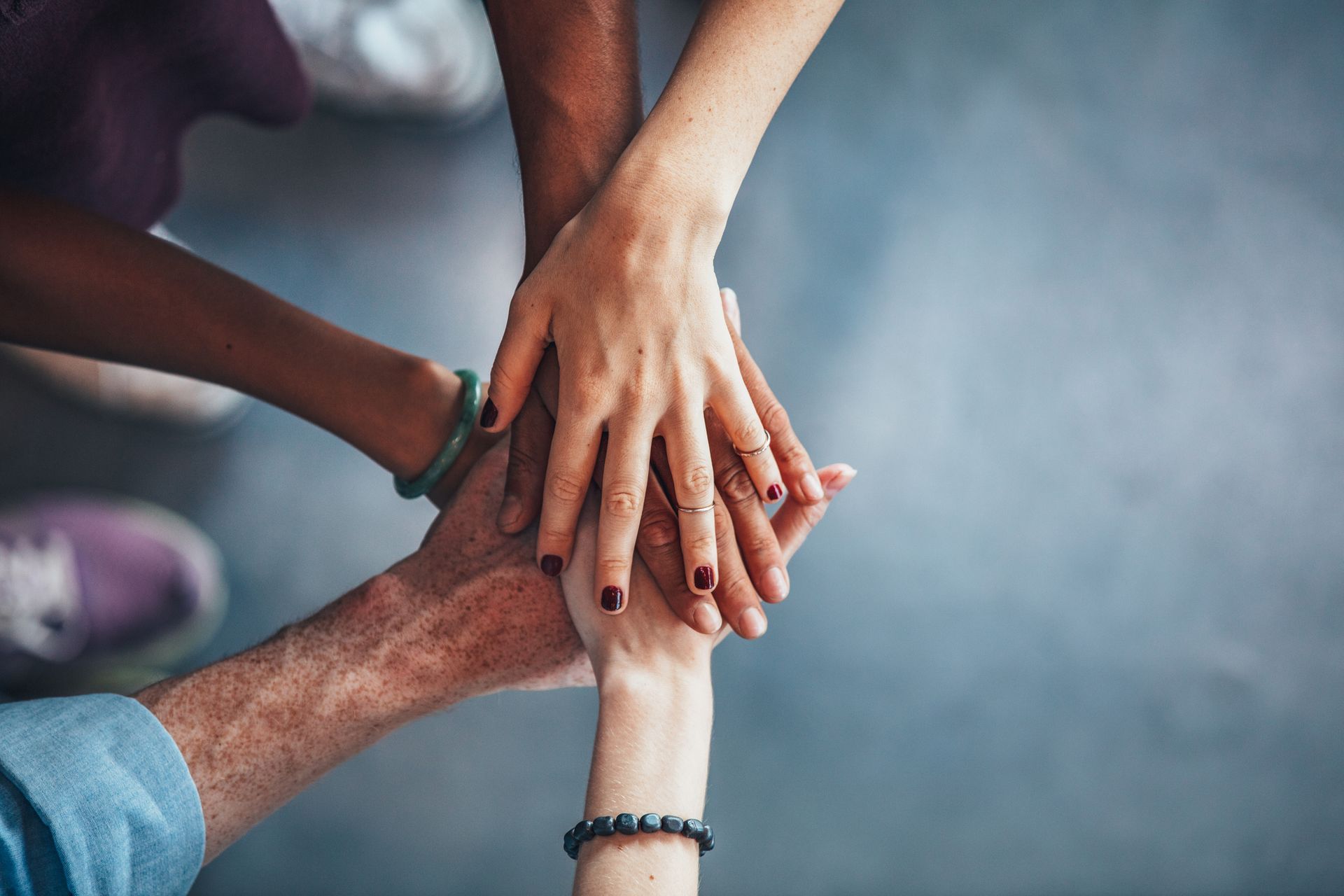 A group of people are putting their hands together.