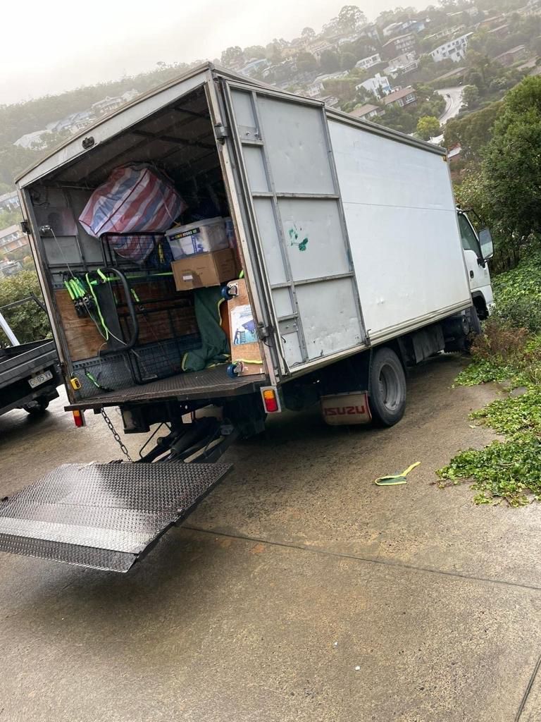A white moving truck is parked on the side of the road.