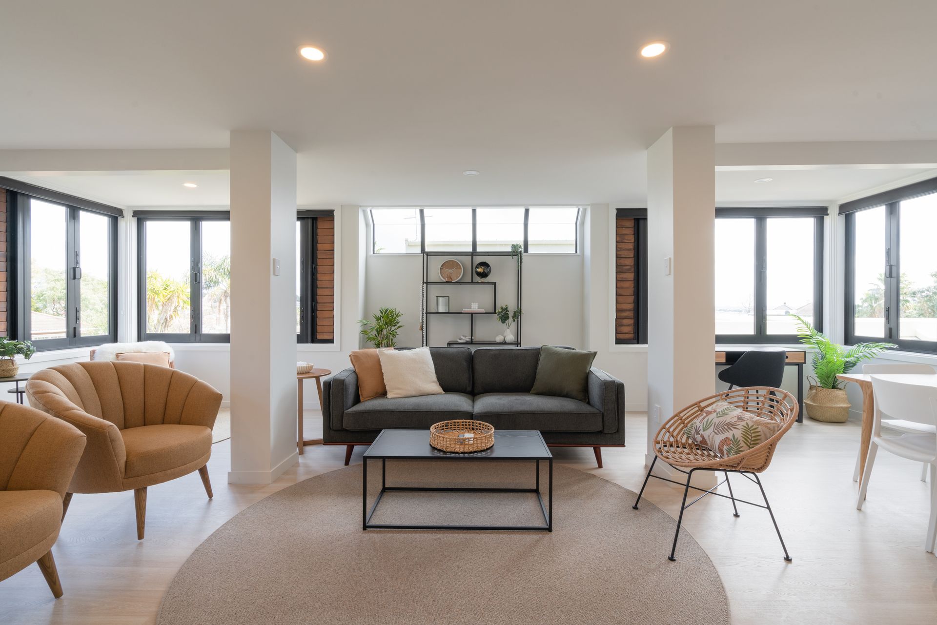 A living room with a couch , chairs , and a coffee table.