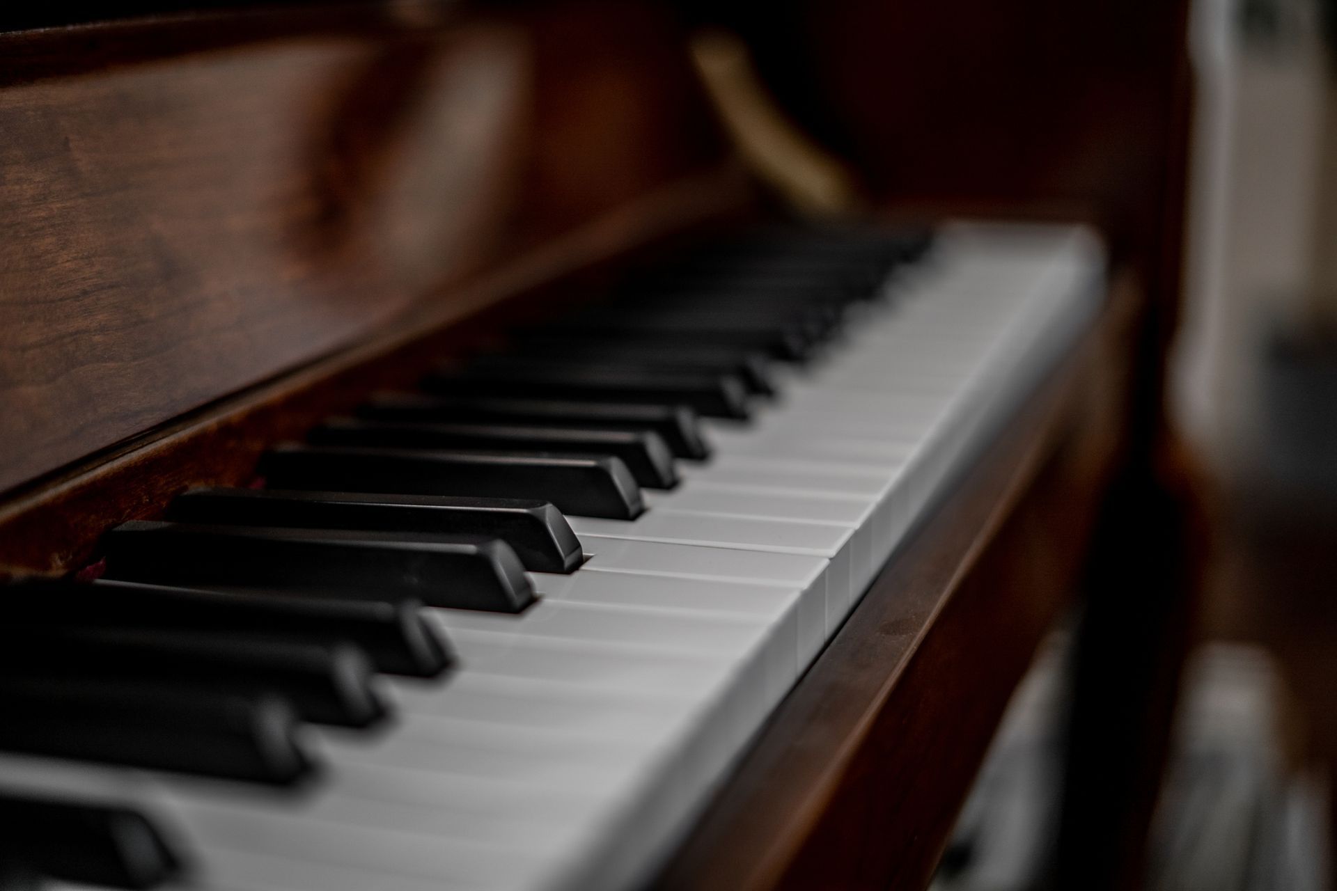 A close up of a piano keyboard in a dark room.
