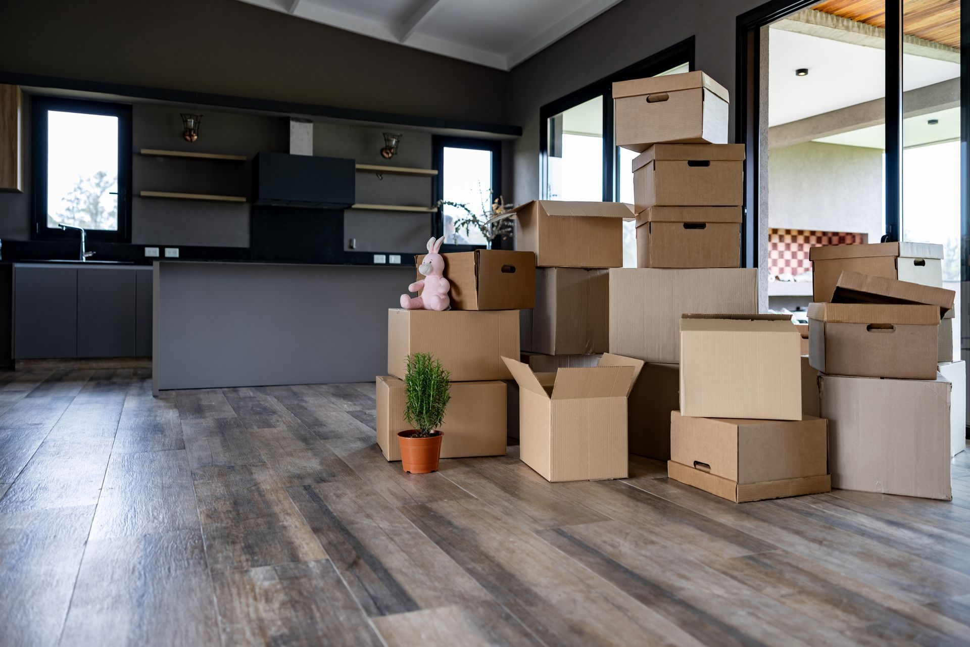 A bunch of cardboard boxes are stacked on top of each other in a living room.