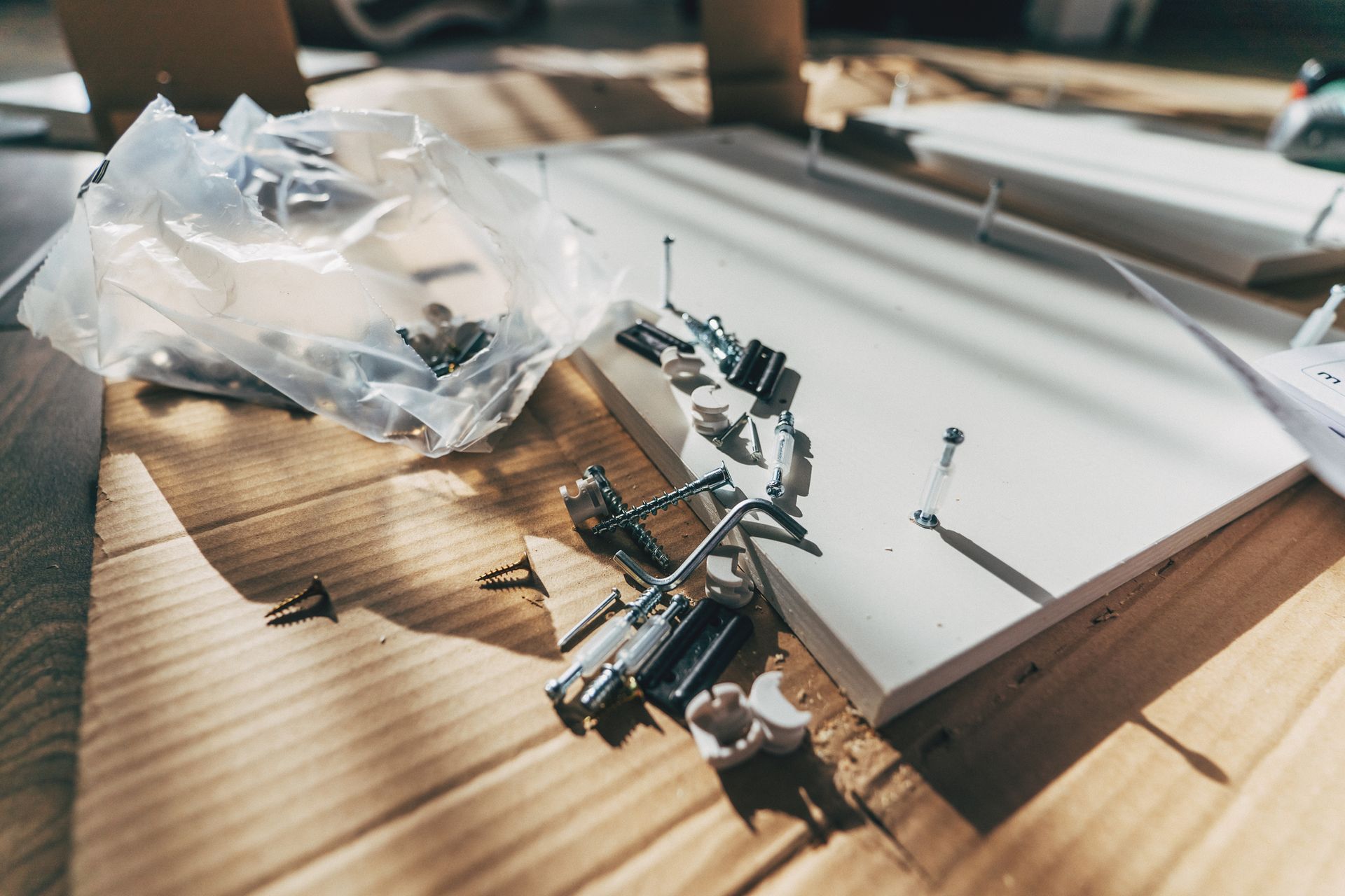 A bunch of screws and nails are laying on a wooden table.