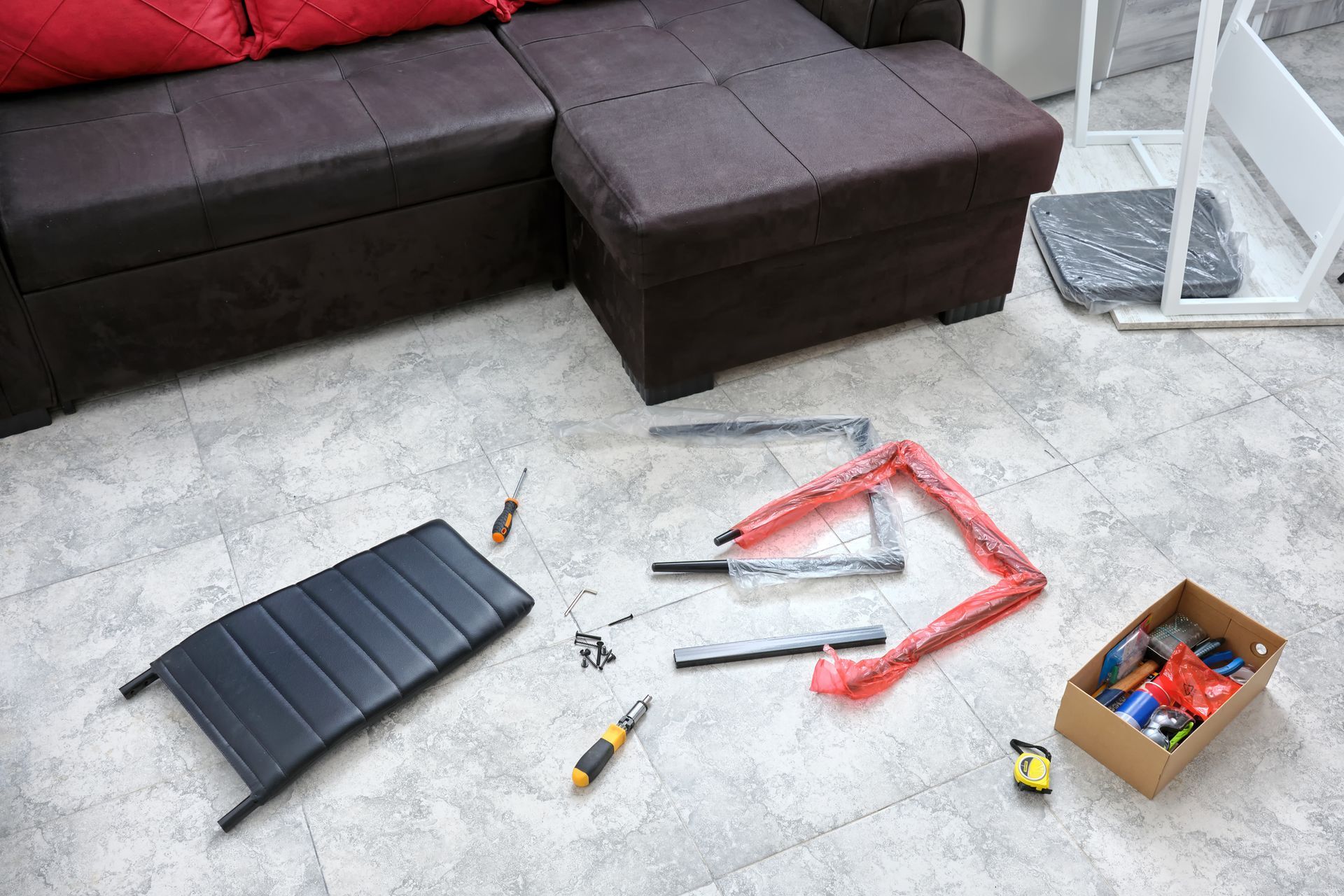 A living room with a couch and a box of tools on the floor.
