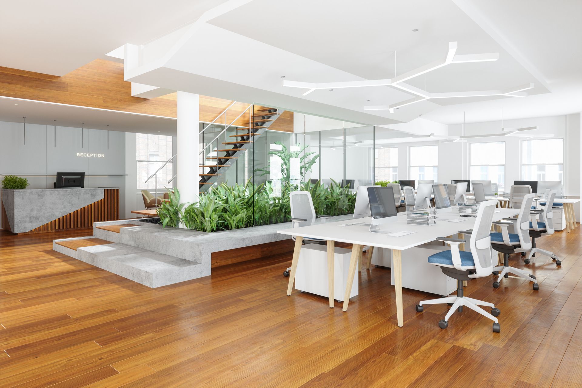 An empty office with wooden floors and white desks and chairs.