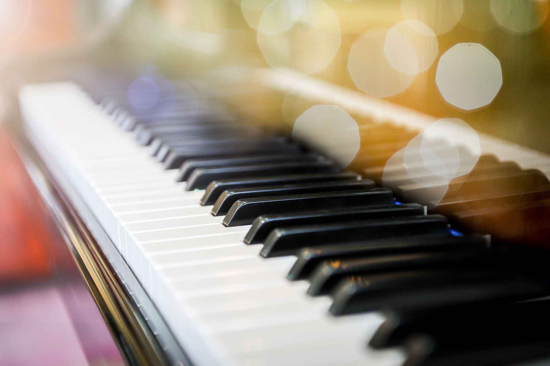 A close up of a piano keyboard with a blurry background.