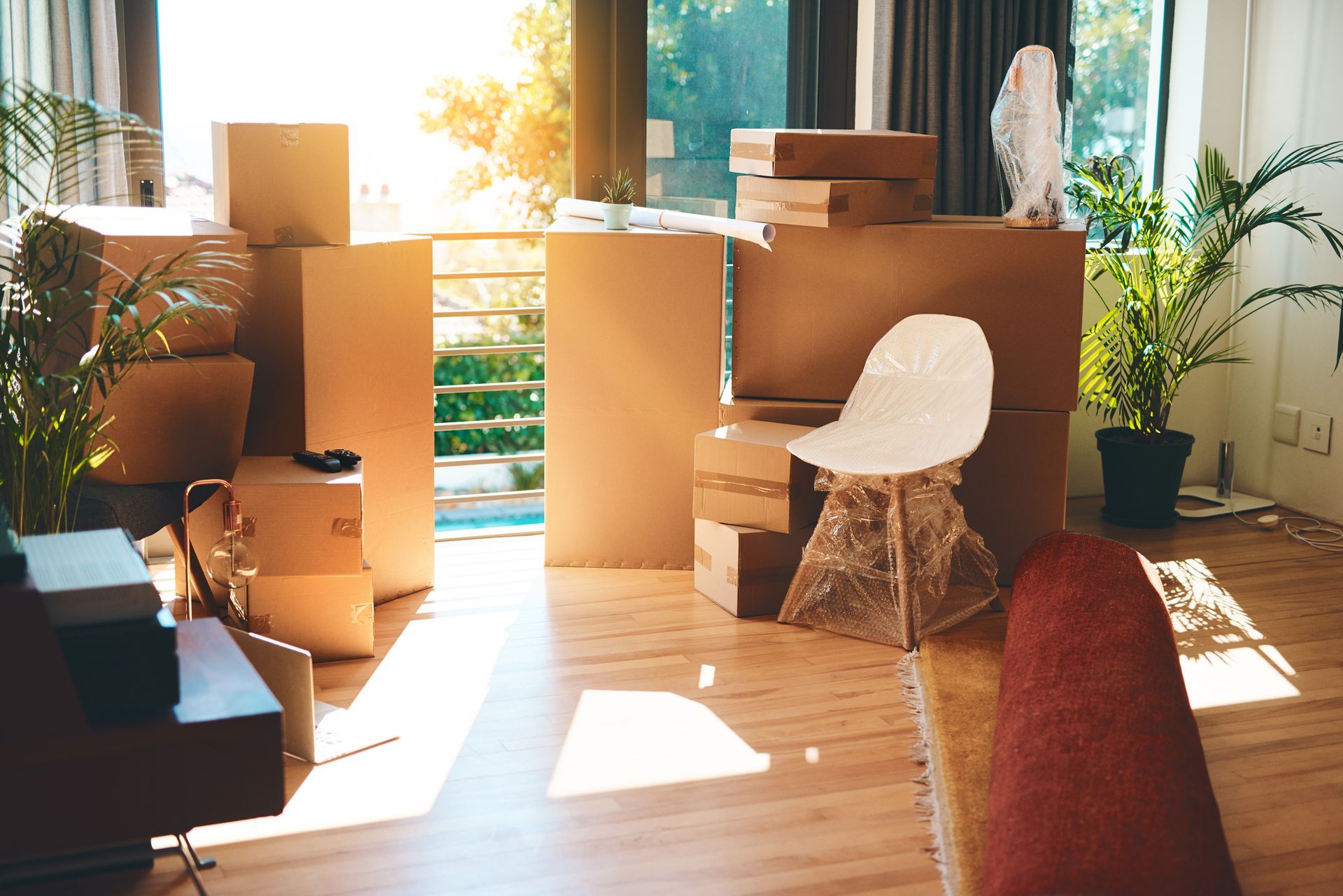A living room filled with cardboard boxes and a chair.