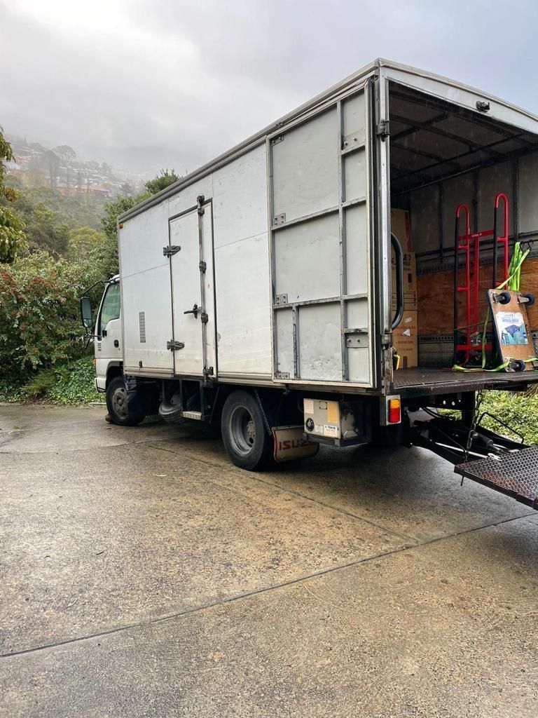 A white moving truck is parked on the side of the road.
