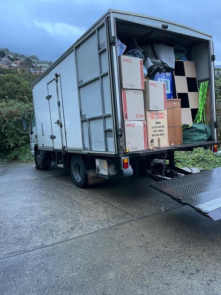 A moving truck filled with boxes is parked on the side of the road.