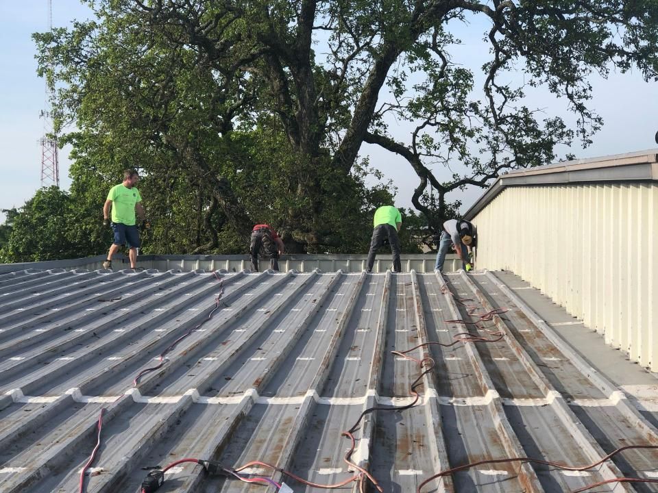 A group of men are working on the roof of a building.