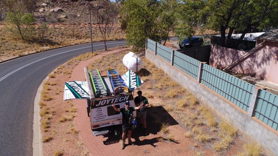 An Aerial View Of A Group Of People Standing On The Side Of A Road — Joytech In Ciccone, NT