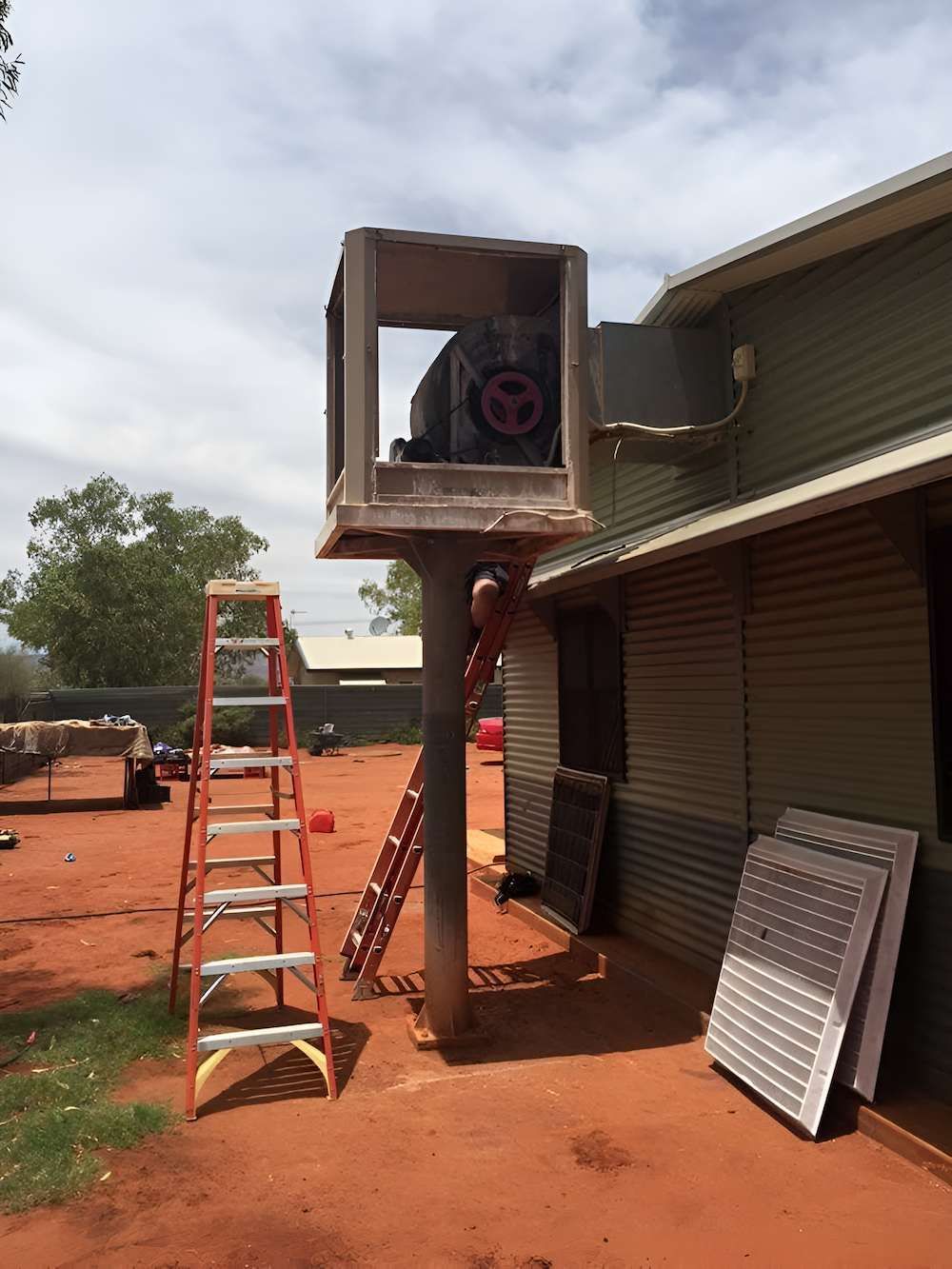 A Ladder is Sitting on Top of a Pole in Front of a Building — Joytech In Ciccone, NT