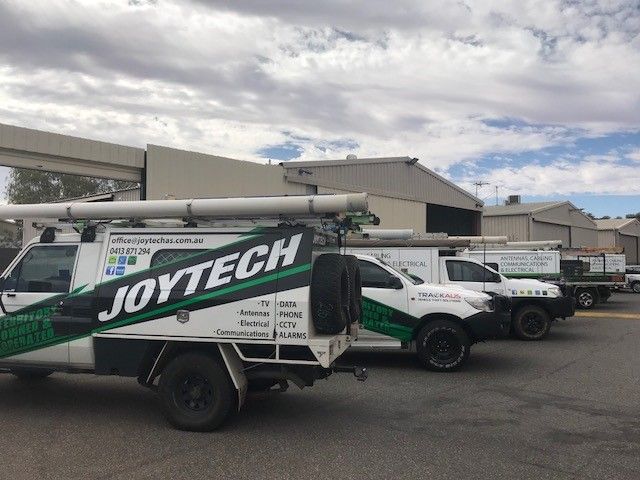 A Row Of Joytech Trucks Are Parked In A Parking Lot — Joytech In Ciccone, NT