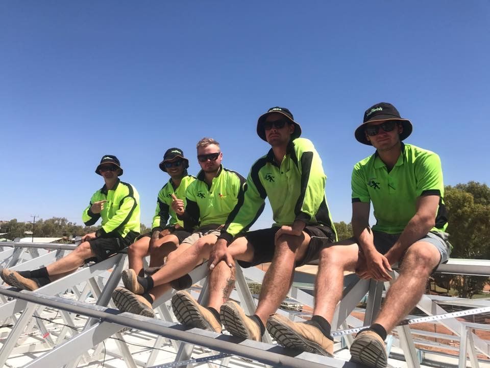 A Group Of Construction Workers Are Sitting On Top Of A Metal Structure — Joytech In Ciccone, NT