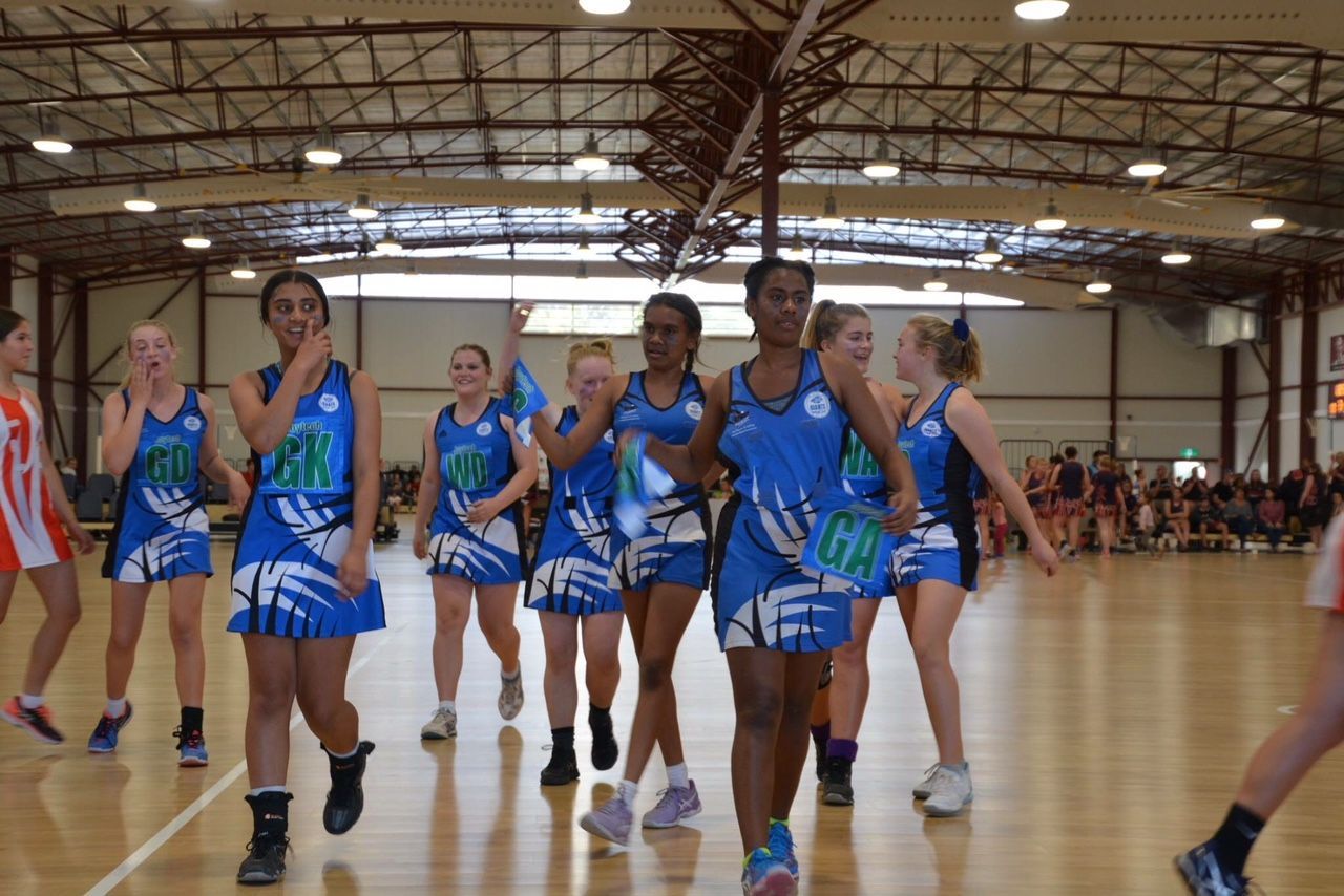 A Group Of Young Girls Are Playing Netball In A Gym — Joytech In Ciccone, NT