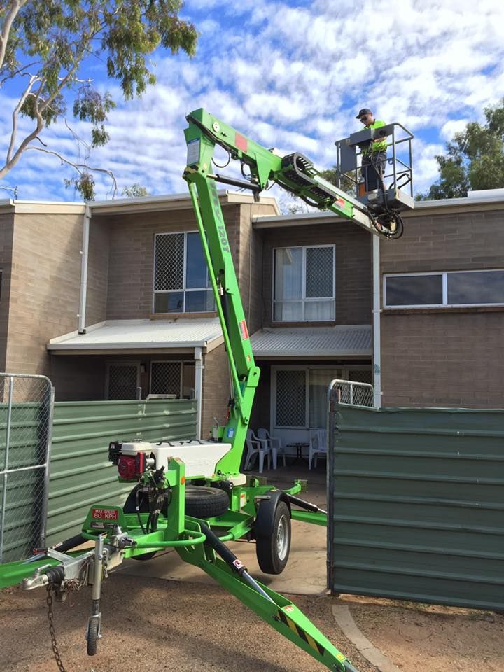 A Green Crane Is Parked In Front Of A Brick Building — Joytech In Ciccone, NT