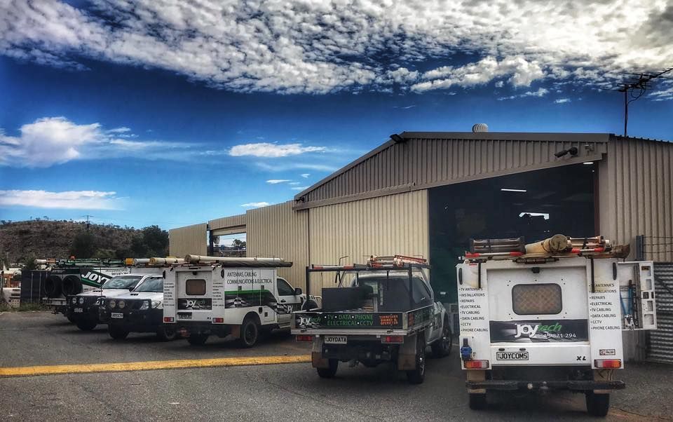 A Row Of Trucks Parked In Front Of A Building — Joytech In Ciccone, NT