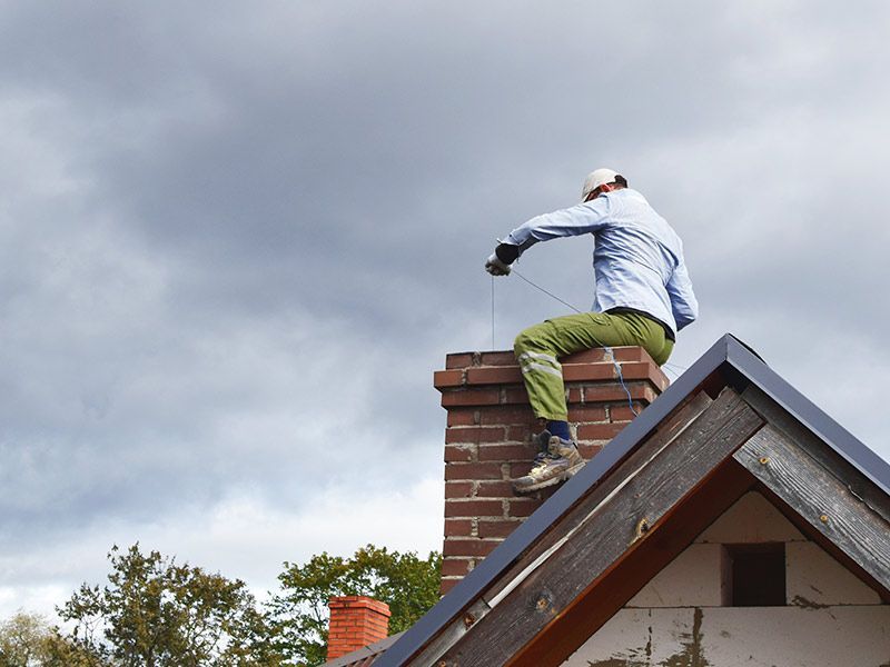 Man On Top Of Chimney Cleaning