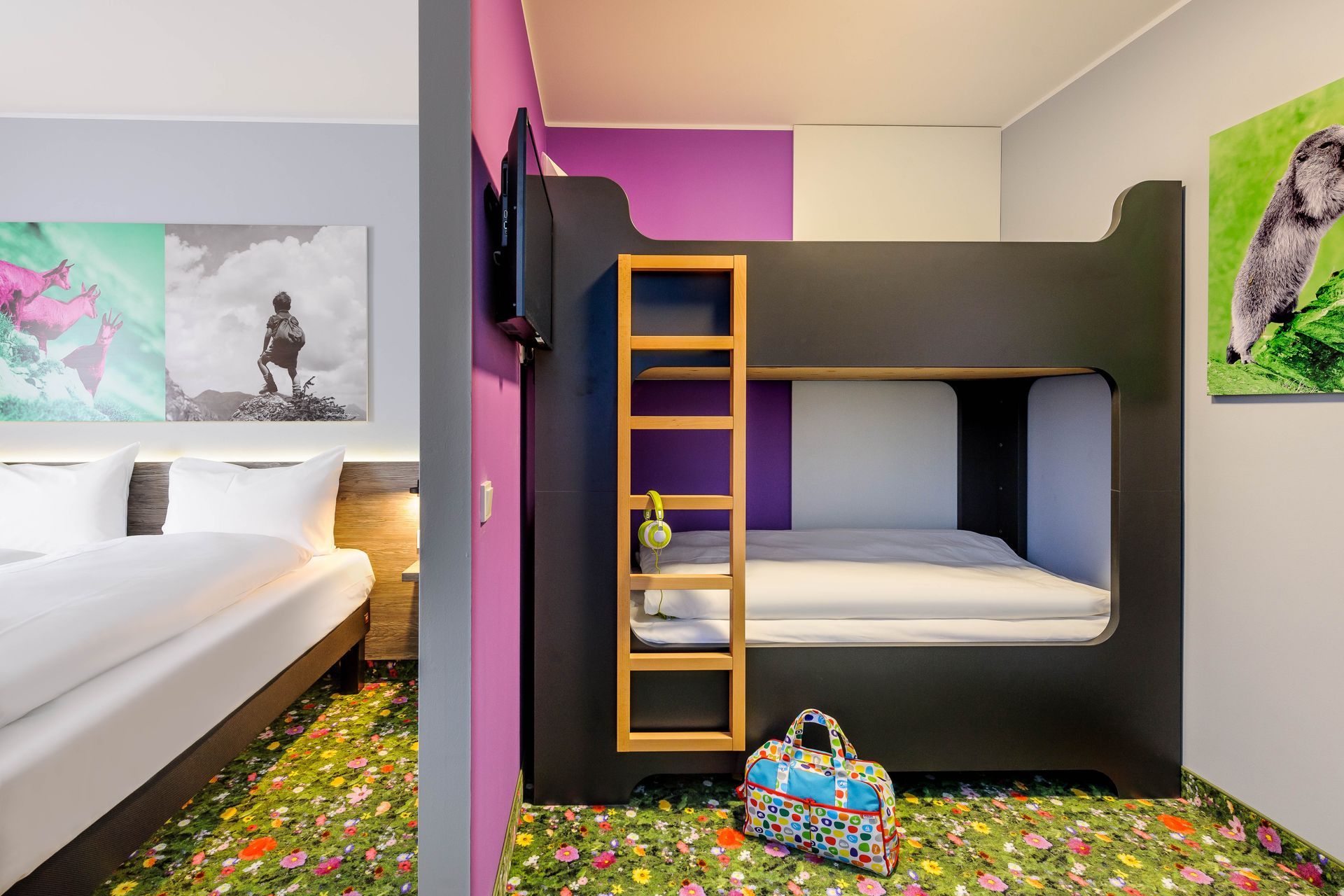 Kinderzimmer mit Etagenbett, Leiter und buntem Blumenteppich neben einem weißen Bett