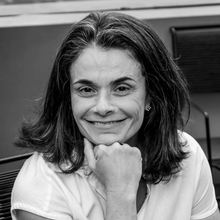 Uma foto em preto e branco de uma mulher com a mão no queixo.