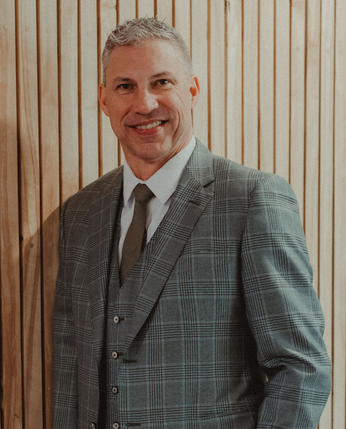 A man in a suit and tie is sitting in a chair.
