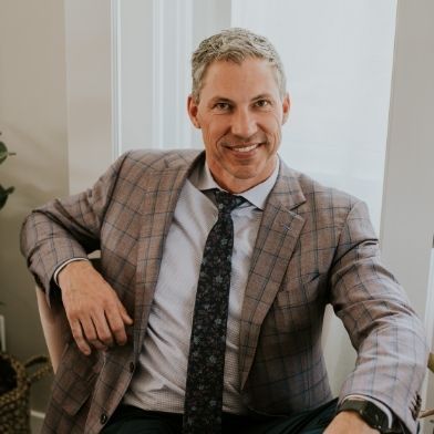 A man in a suit and tie is sitting in a chair.