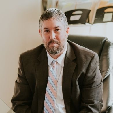 A man in a suit and tie is sitting in a chair.