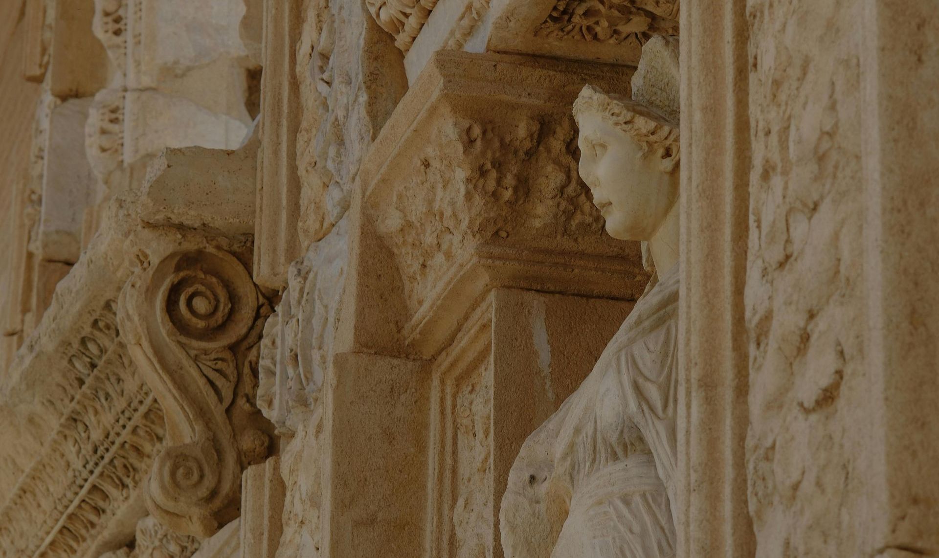 A close-up view of ancient ruins with a statue carved into the stone