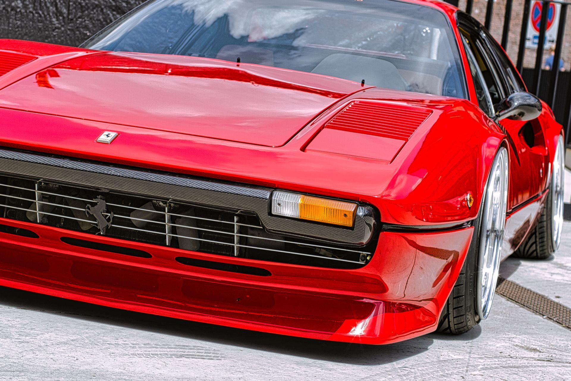 Red sports car parked on a street, front view with glossy paint and black grille Ferrai 308