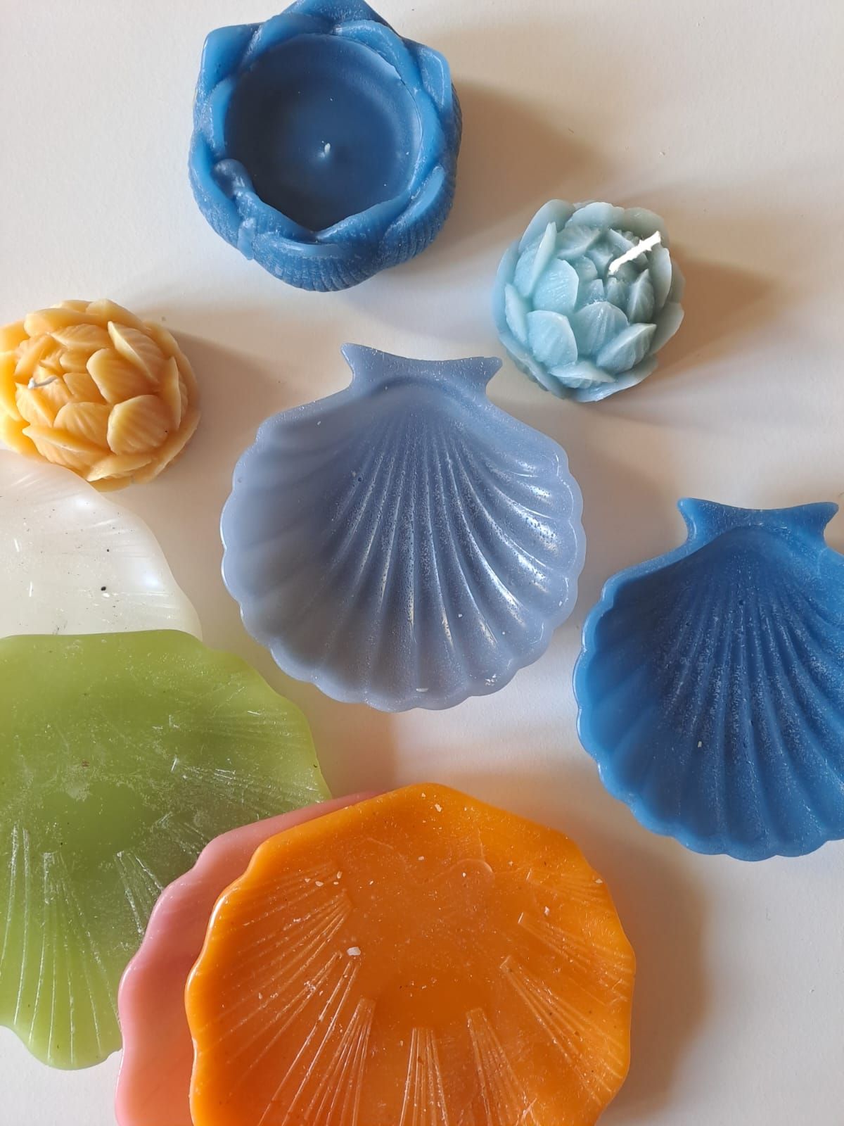 Un groupe de bougies en forme de coquillage sont posées sur une table