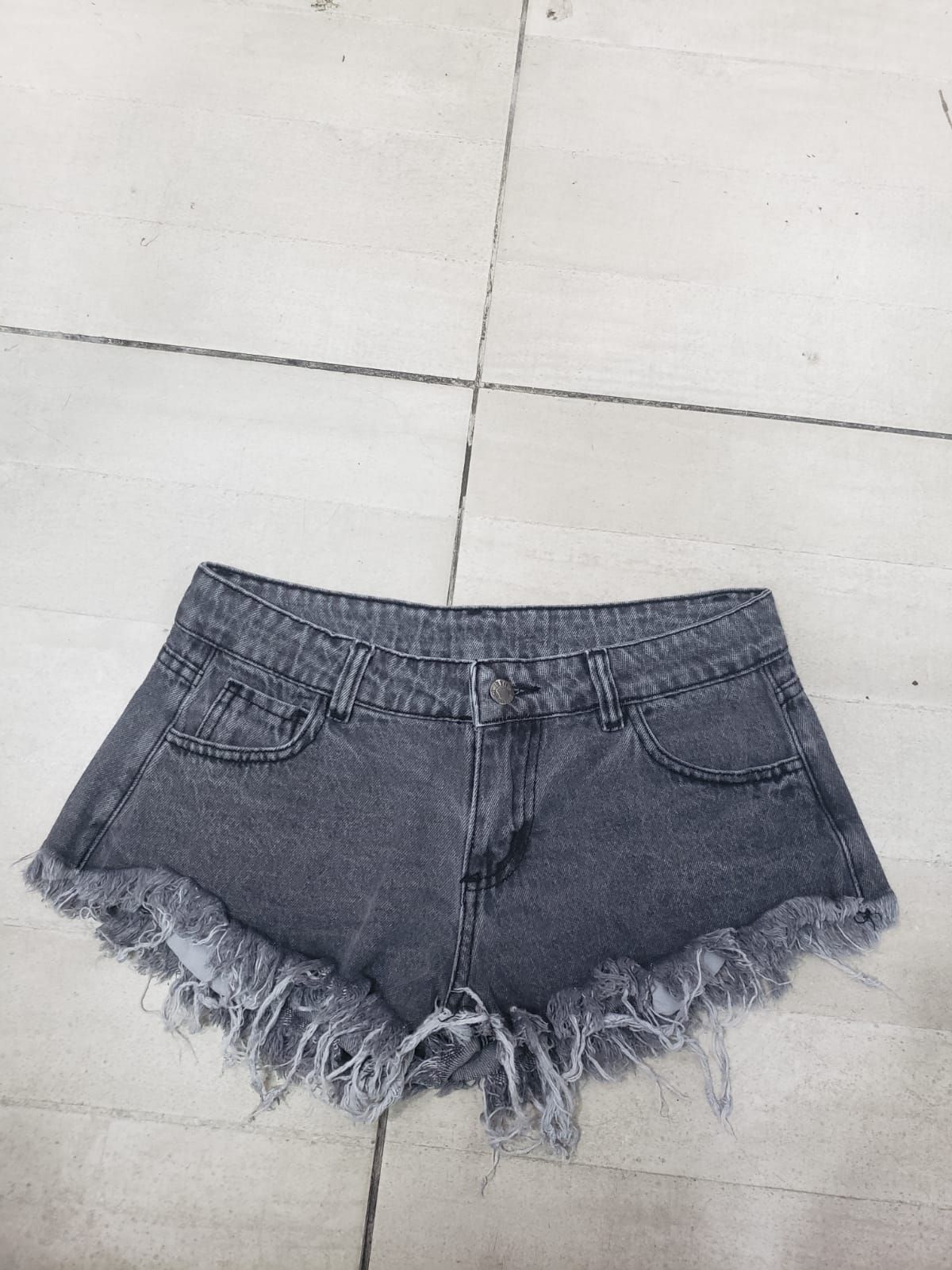 Shorts vaqueros grises con bordes deshilachados.