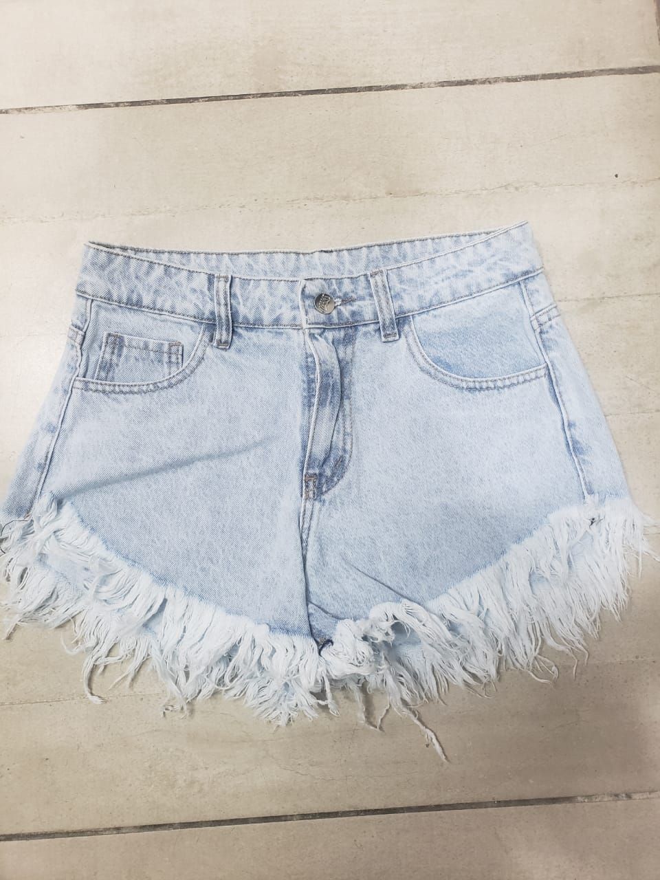 Shorts vaqueros de color azul claro con bordes con flecos.