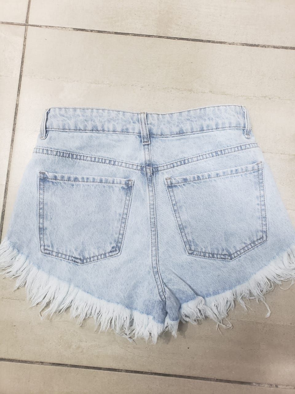 Shorts vaqueros de color azul claro con bordes con flecos.