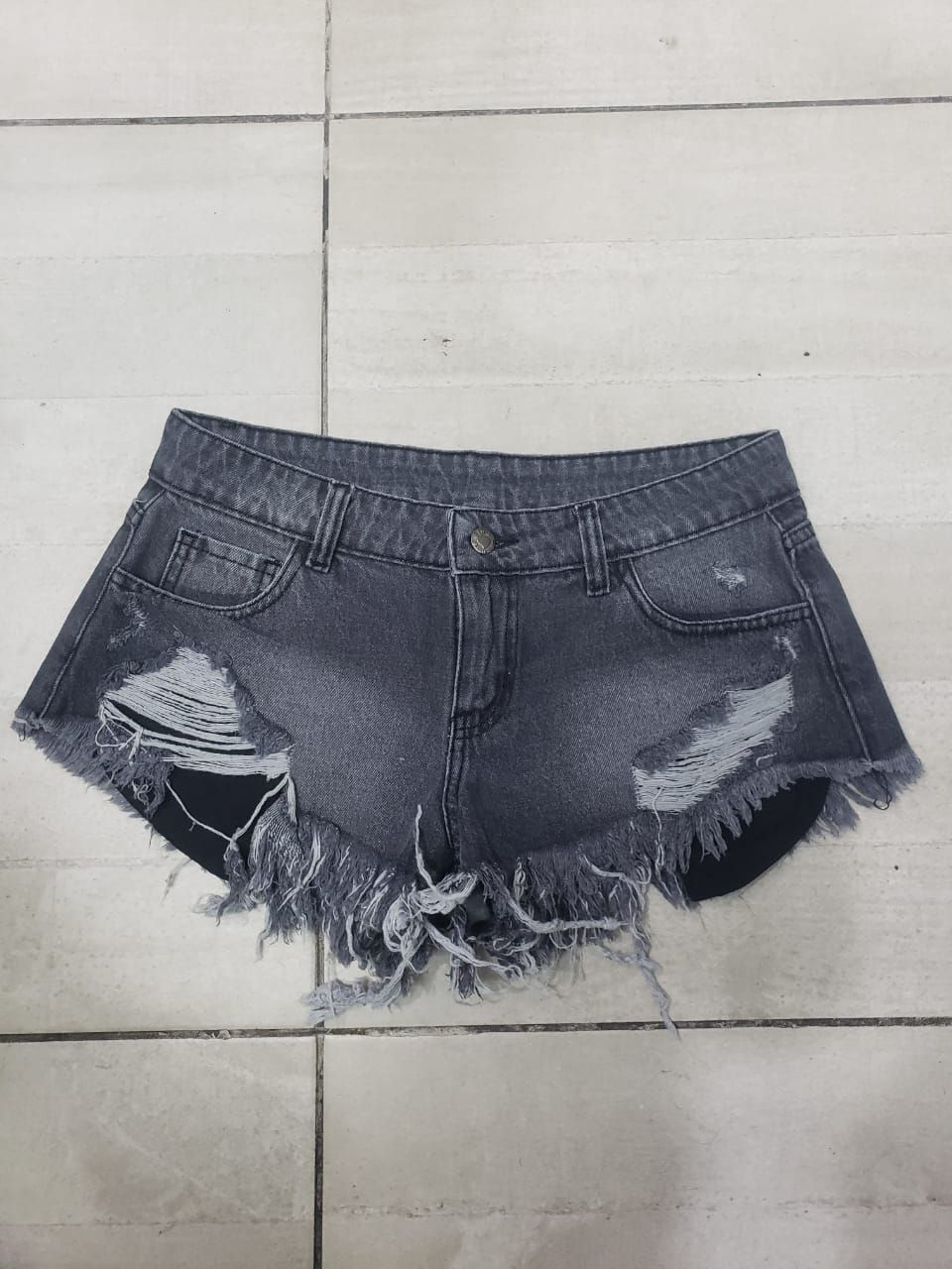 Shorts de mezclilla gris oscuro con detalles desgastados y bordes deshilachados.