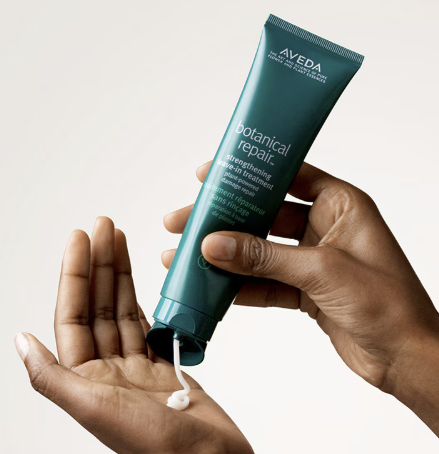 Aveda Botanical Repair Styling Cream being dispensed into a person’s hand