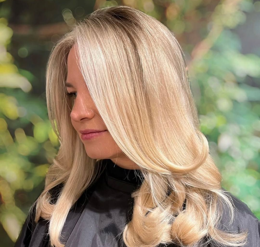 Smooth, glossy blonde hair with soft movement, showing a healthy and well styled natural finis