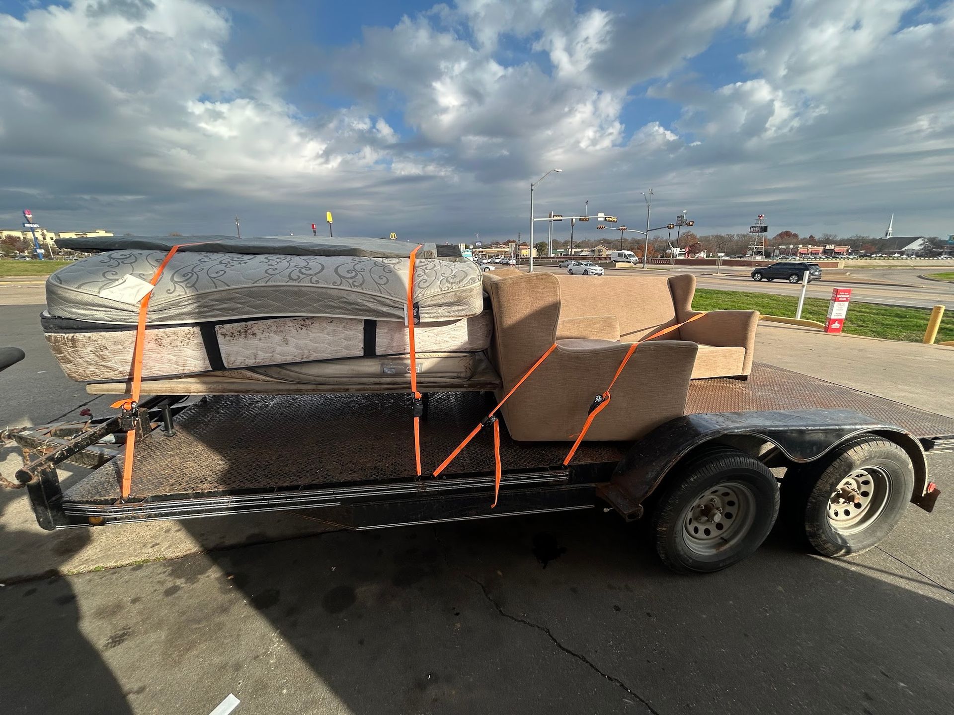 A trailer with a couch and a mattress on it.