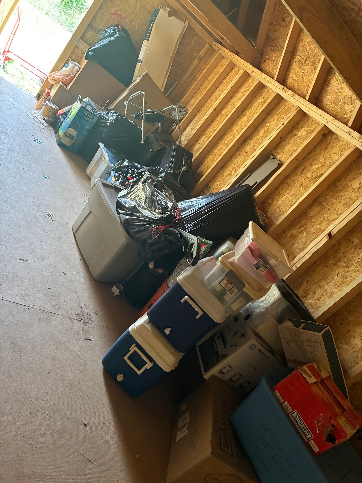 A bunch of boxes and coolers are stacked on top of each other in a garage.