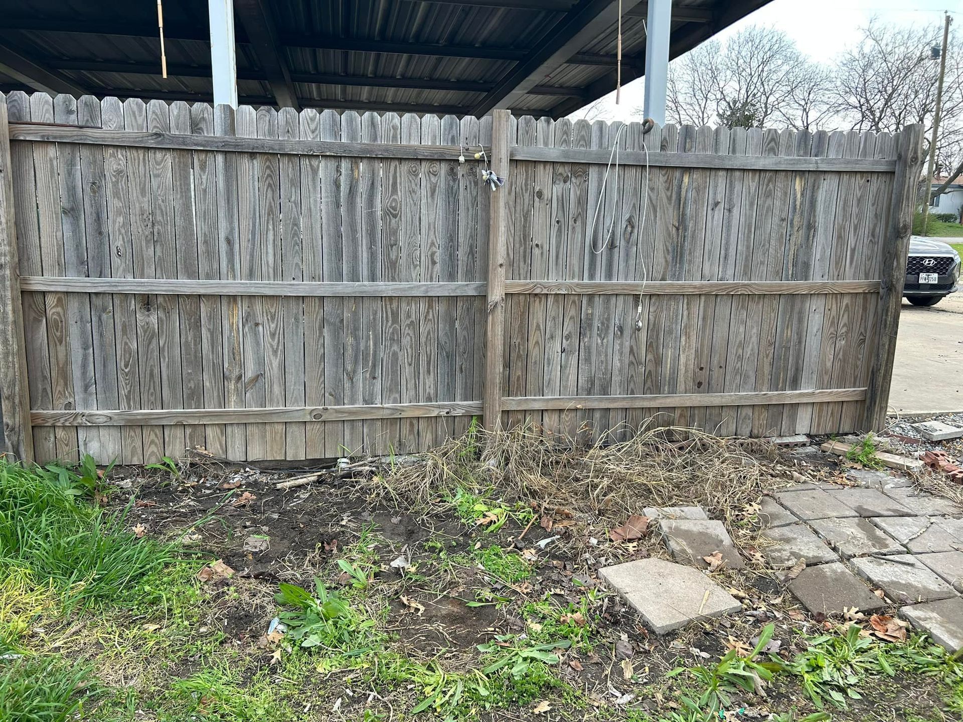 A wooden fence with a car parked behind it