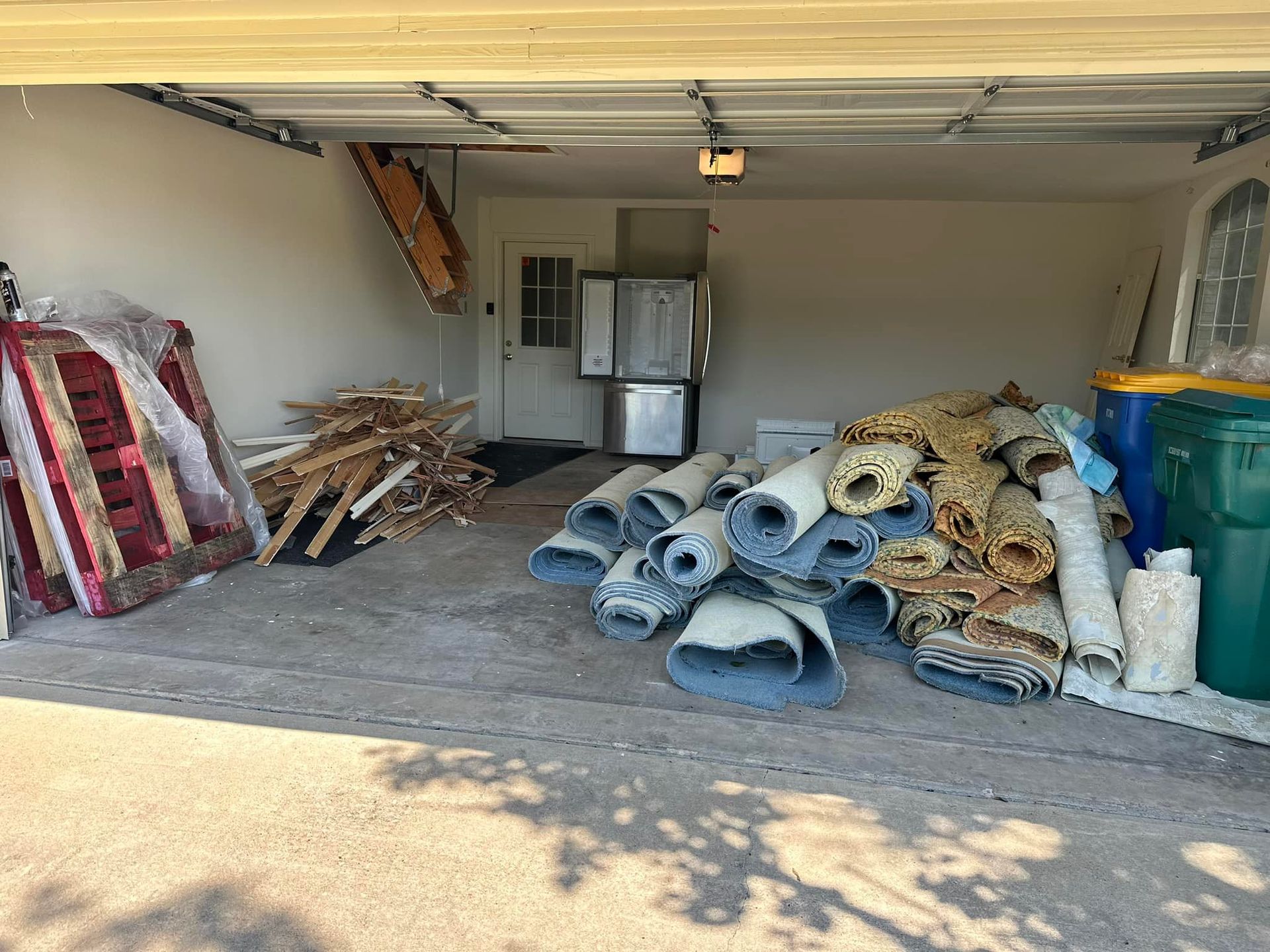A garage filled with a lot of junk and a refrigerator.