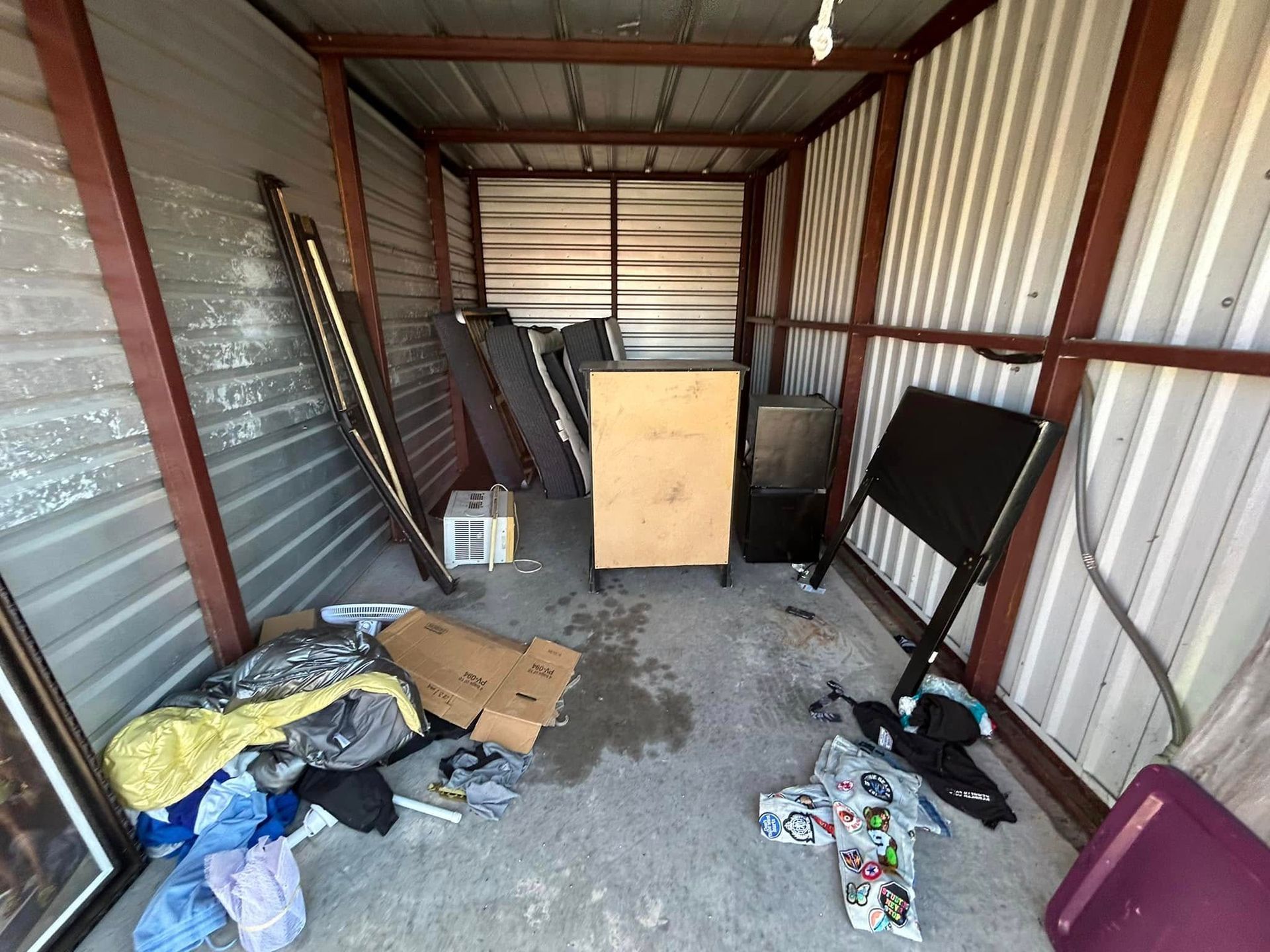 A shed filled with lots of junk and a table.